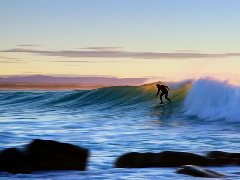 Surfeur sur une vague au coucher du soleil, session surf en fin de journée, Côte Landaise.
